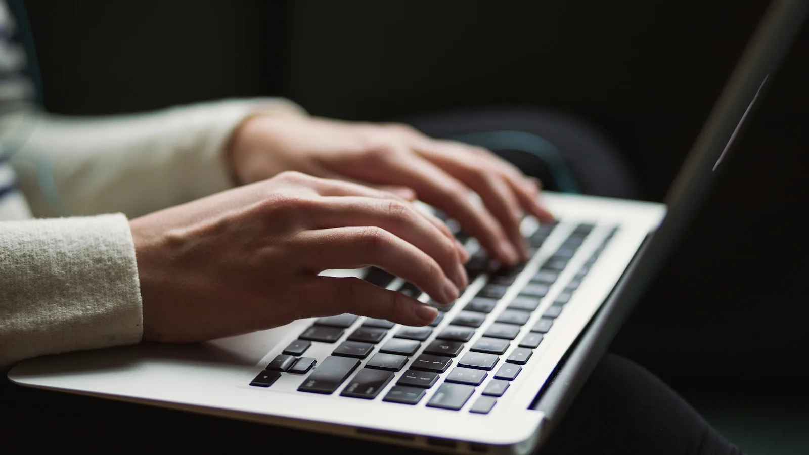 Mains tapant sur un clavier d'ordinateur portable illustrant un test IPTV gratuit
